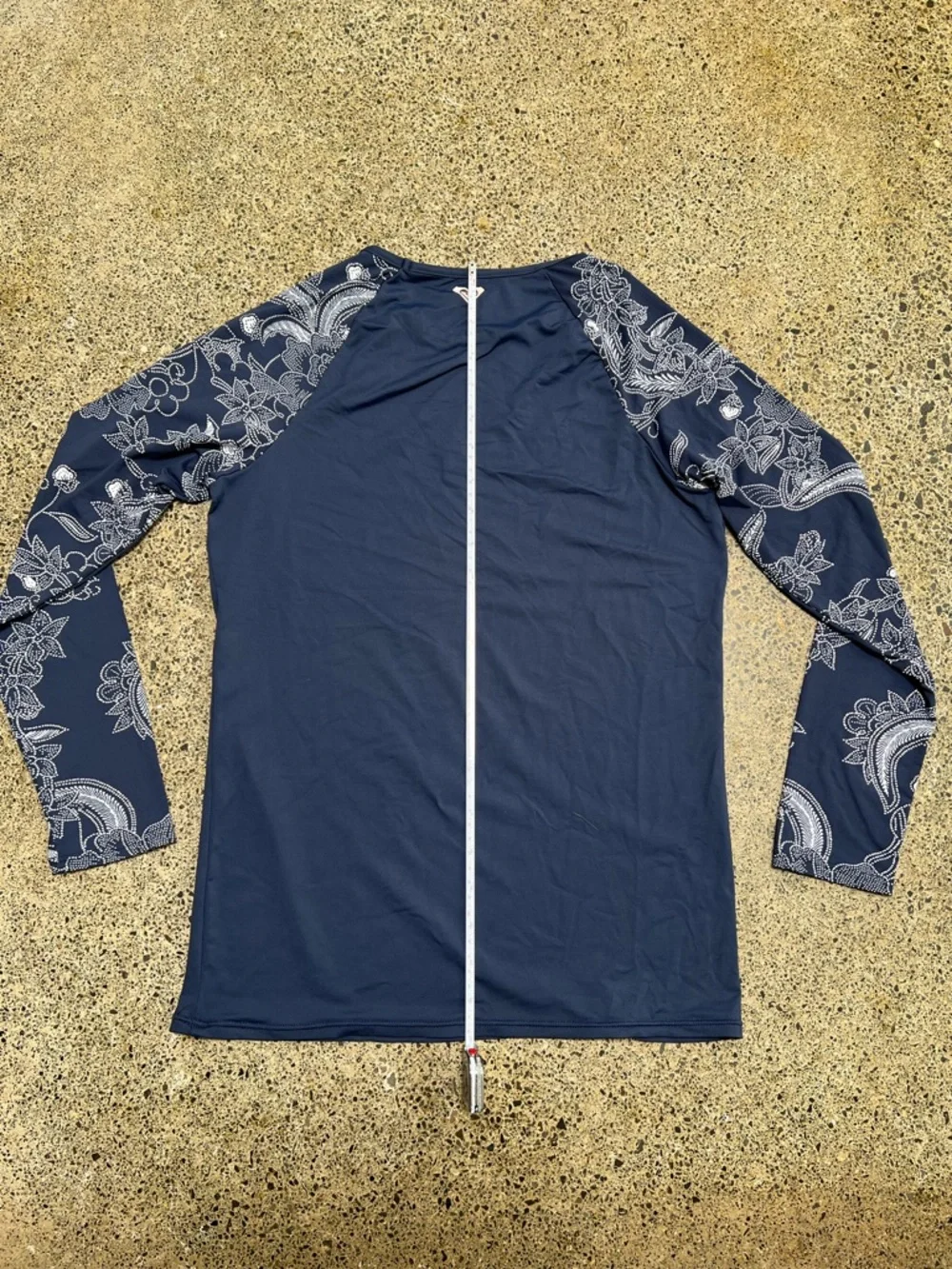 Roxy rashguard in blue with white floral design at sleeves